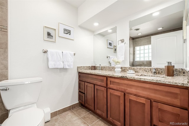 bathroom with toilet, a sink, tile patterned flooring, double vanity, and tiled shower