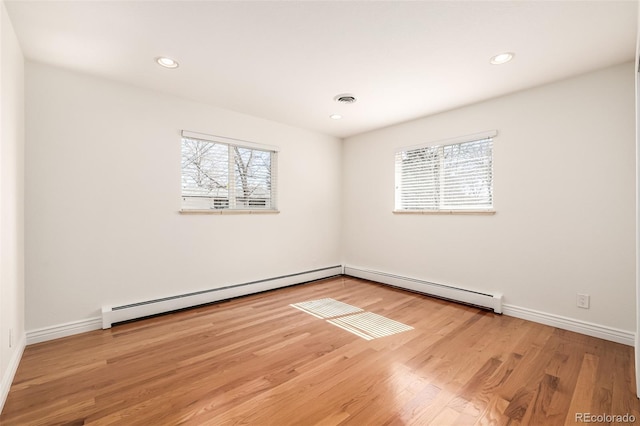 spare room featuring wood finished floors, visible vents, baseboards, recessed lighting, and baseboard heating