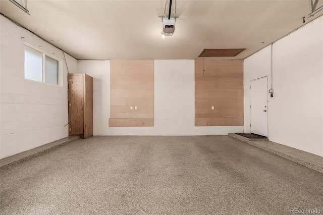 garage with concrete block wall and a garage door opener