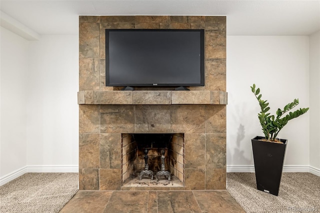 details with a tiled fireplace and baseboards