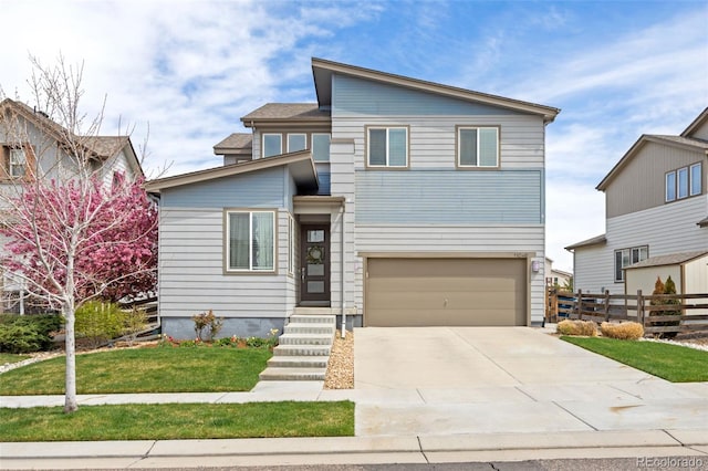 contemporary house with fence, an attached garage, concrete driveway, and a front yard