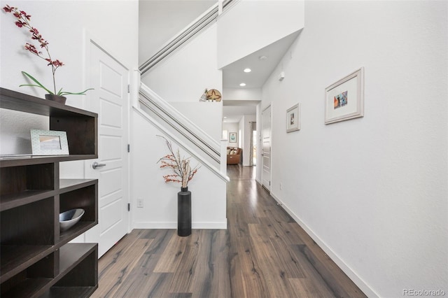 interior space with baseboards, stairs, recessed lighting, and dark wood-type flooring
