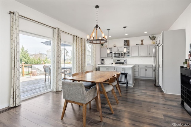 dining room with a chandelier, dark wood-type flooring, and recessed lighting