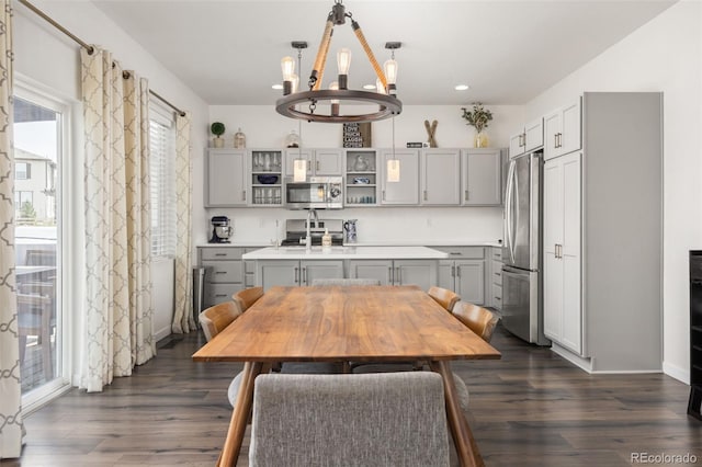kitchen featuring open shelves, a notable chandelier, gray cabinets, appliances with stainless steel finishes, and dark wood-style floors