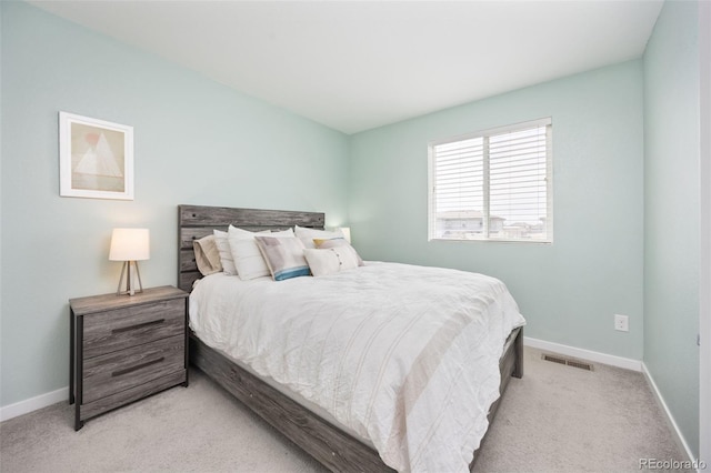 bedroom featuring baseboards, visible vents, and light colored carpet