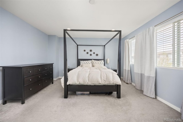 bedroom with light colored carpet and baseboards