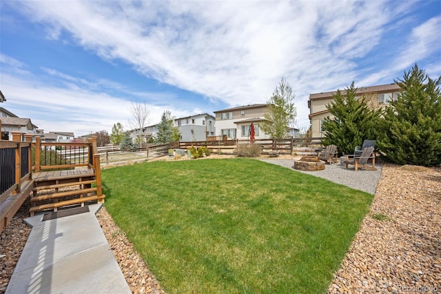 view of yard featuring a fenced backyard, an outdoor fire pit, and a residential view