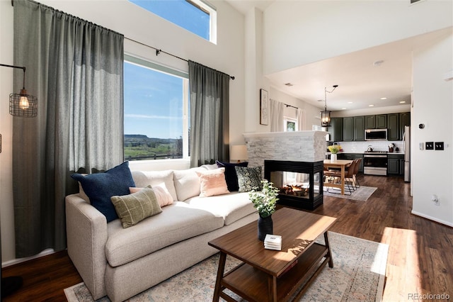 4963 Collingswood Dr, Highlands Ranch, CO 80130 - living area featuring dark wood-style flooring, a towering ceiling, a multi sided fireplace, and recessed lighting