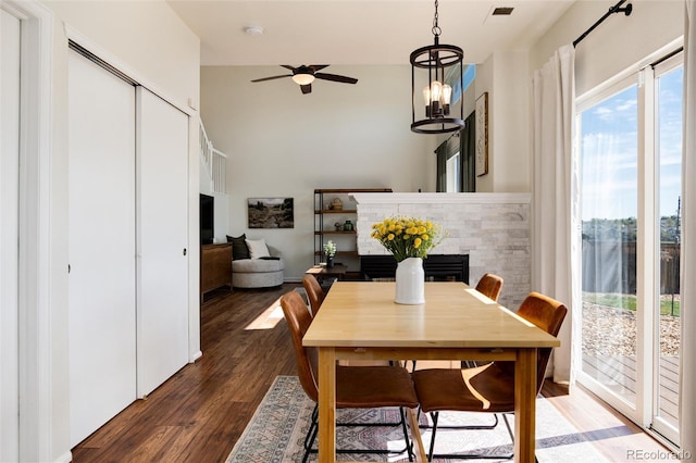 4963 Collingswood Dr, Highlands Ranch, CO 80130 - dining area with a fireplace, a ceiling fan, wood finished floors, a high ceiling, and a chandelier