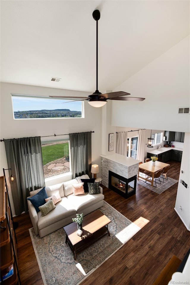 4963 Collingswood Dr, Highlands Ranch, CO 80130 - living room featuring a towering ceiling, wood finished floors, a ceiling fan, and a multi sided fireplace
