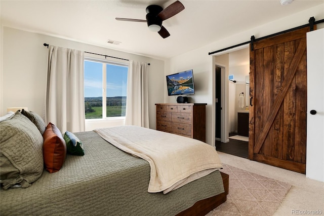 4963 Collingswood Dr, Highlands Ranch, CO 80130 - bedroom featuring a barn door, light carpet, ceiling fan, and ensuite bathroom