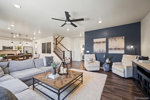 living room featuring ceiling fan and dark hardwood / wood-style floors