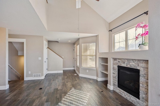 unfurnished living room featuring stairway, wood finished floors, visible vents, and baseboards