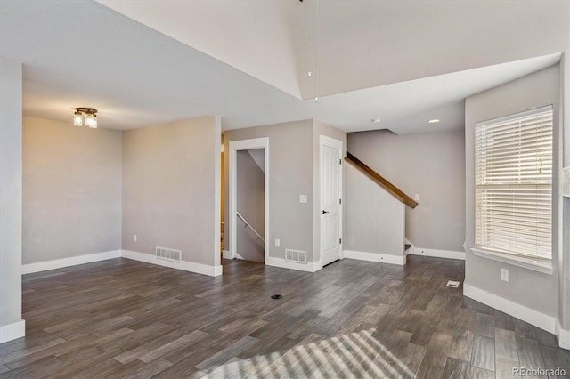 unfurnished room featuring visible vents, baseboards, and wood finished floors