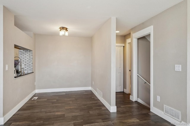 empty room featuring visible vents, baseboards, and wood finished floors