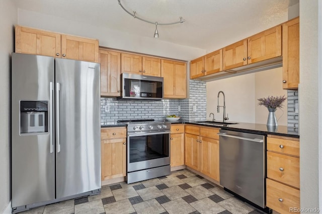 kitchen with a sink, dark countertops, tasteful backsplash, and stainless steel appliances