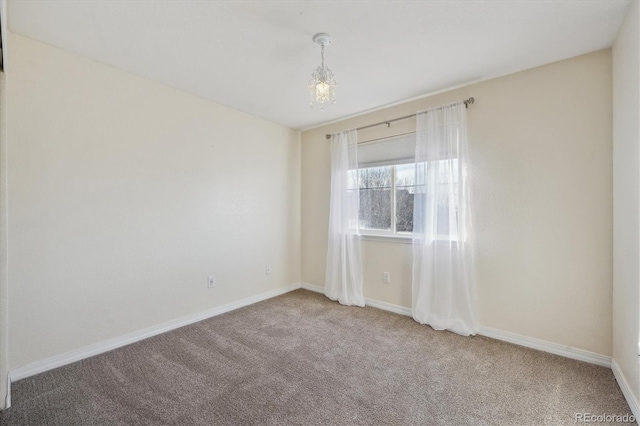 carpeted spare room with baseboards