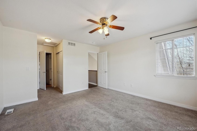 empty room with attic access, baseboards, visible vents, and carpet floors