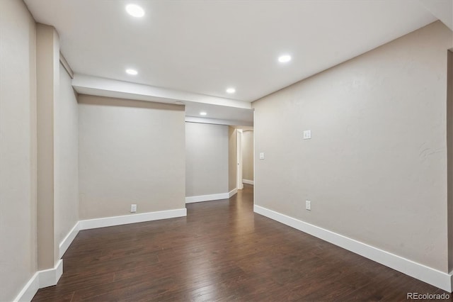 below grade area with dark wood finished floors, recessed lighting, and baseboards