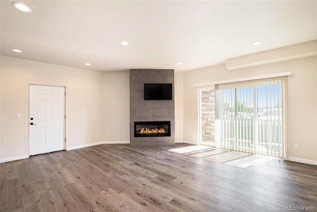 unfurnished living room with a fireplace and hardwood / wood-style flooring