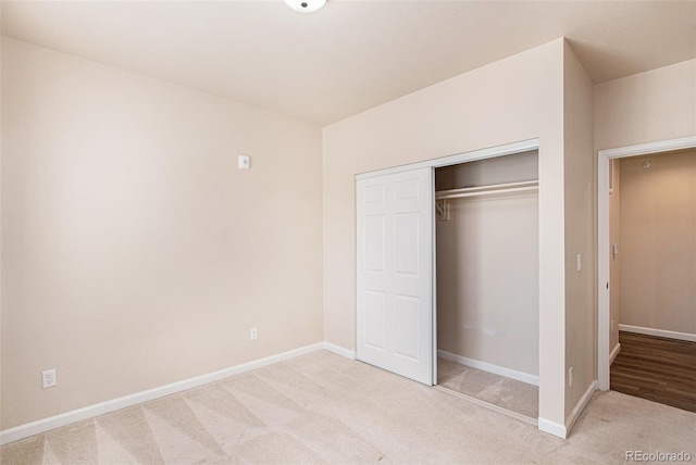 unfurnished bedroom with light carpet and a closet