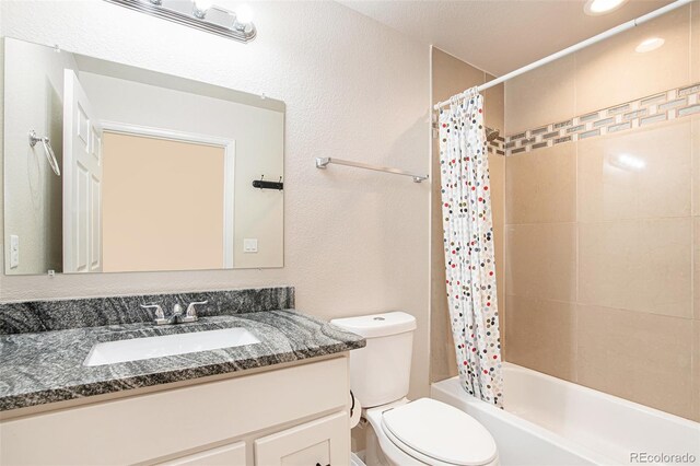 full bathroom with vanity, shower / bath combo, and toilet