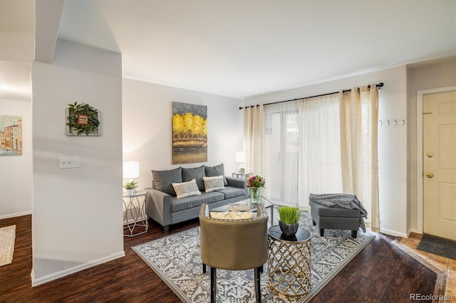 living area with baseboards and wood finished floors