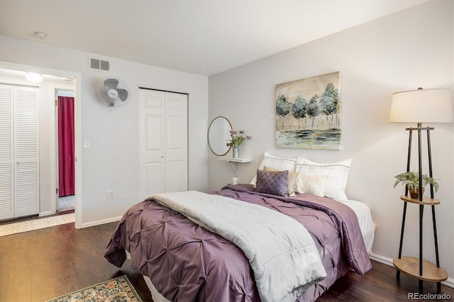 bedroom featuring a closet, wood finished floors, visible vents, and baseboards