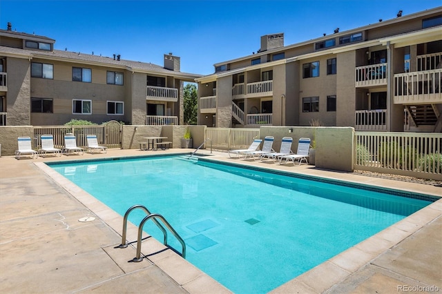 community pool featuring a patio area and fence