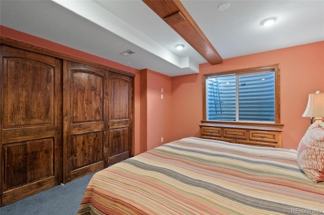 bedroom with carpet flooring and beam ceiling