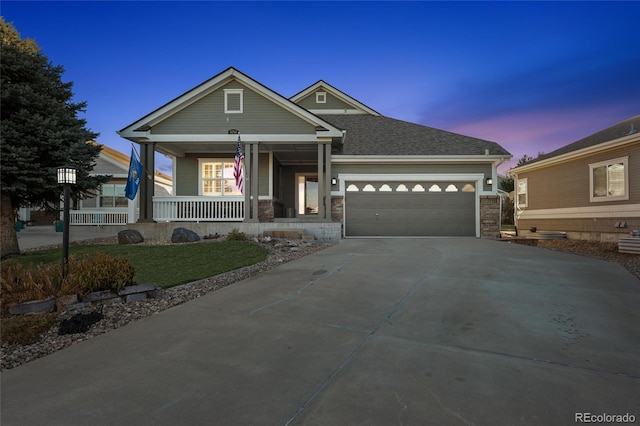 view of front of home featuring a porch, a yard, and a garage