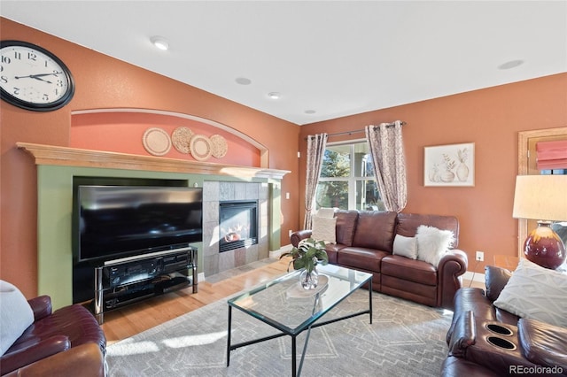 living room with a fireplace and light wood-type flooring