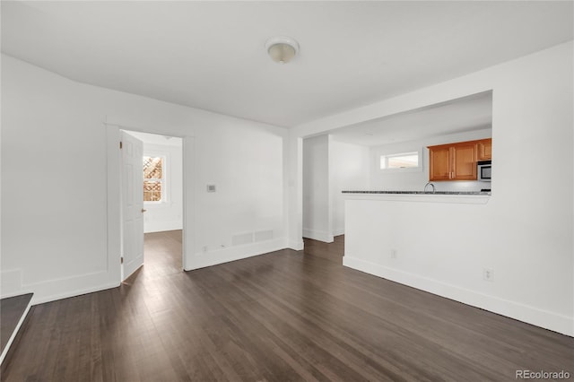 unfurnished living room with dark hardwood / wood-style flooring