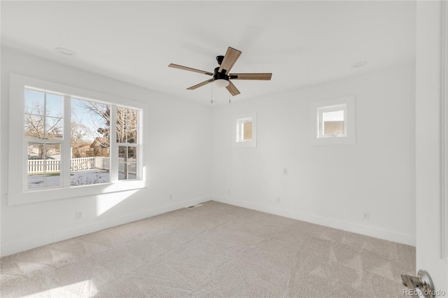 unfurnished room with ceiling fan, plenty of natural light, and light colored carpet