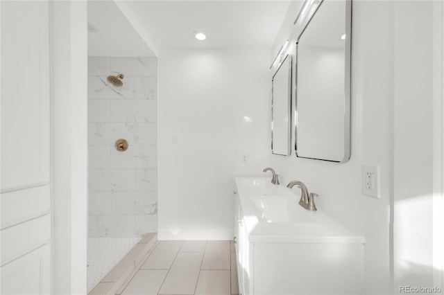 bathroom with a tile shower, tile patterned flooring, and vanity