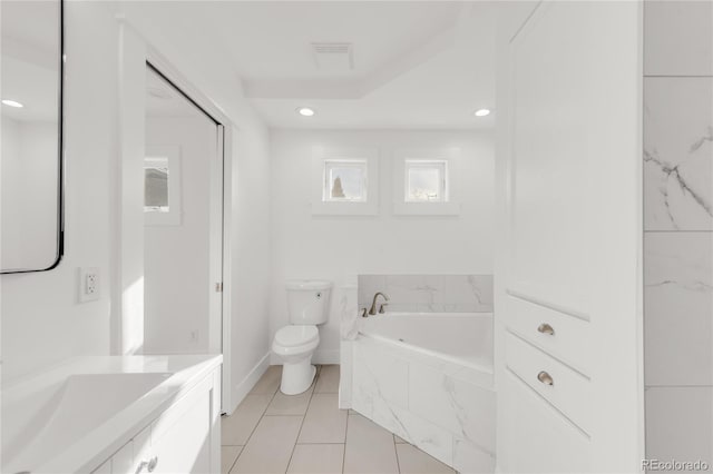 bathroom featuring tiled bath, tile patterned floors, vanity, and toilet