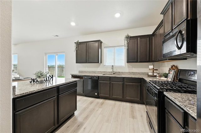 9723 Borderpine Way, Colorado Springs, CO 80925 - kitchen with black appliances, light stone countertops, plenty of natural light, dark brown cabinets, and recessed lighting