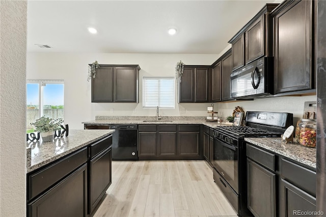 9723 Borderpine Way, Colorado Springs, CO 80925 - kitchen with black appliances, healthy amount of natural light, light stone counters, dark brown cabinets, and recessed lighting