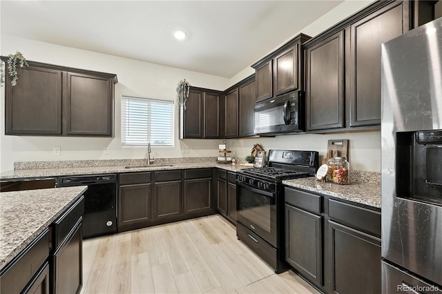 9723 Borderpine Way, Colorado Springs, CO 80925 - kitchen with black appliances, dark brown cabinets, light stone counters, light wood-style floors, and recessed lighting