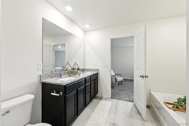 9723 Borderpine Way, Colorado Springs, CO 80925 - full bath with double vanity, wood finished floors, a garden tub, and recessed lighting