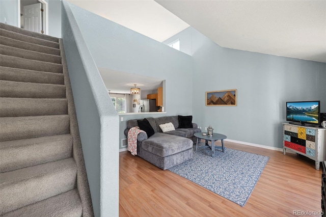 7977 Emerson Ave, Frederick, CO 80530 - living room featuring wood finished floors, stairway, and high vaulted ceiling