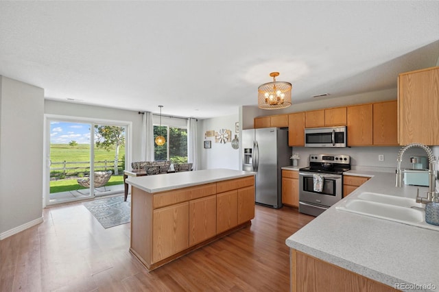 7977 Emerson Ave, Frederick, CO 80530 - kitchen with stainless steel appliances, light countertops, light wood-style floors, and a chandelier