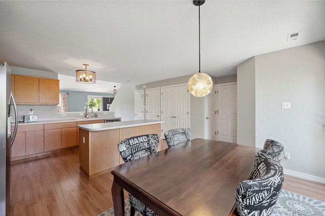 7977 Emerson Ave, Frederick, CO 80530 - dining space with light wood-type flooring and a chandelier