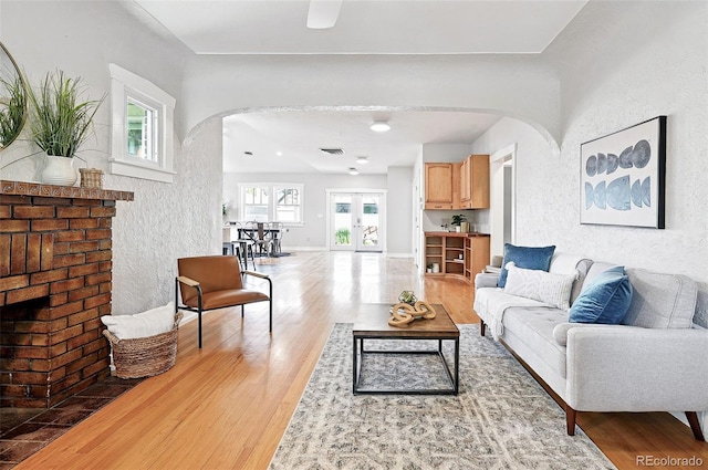 3321 Stuart St, Denver, CO 80212 - living room featuring arched walkways, wood finished floors, and a brick fireplace