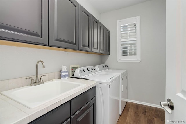 15372 E 117th Ave, Commerce City, CO 80022 - washroom featuring washing machine and clothes dryer, baseboards, cabinet space, and wood finished floors