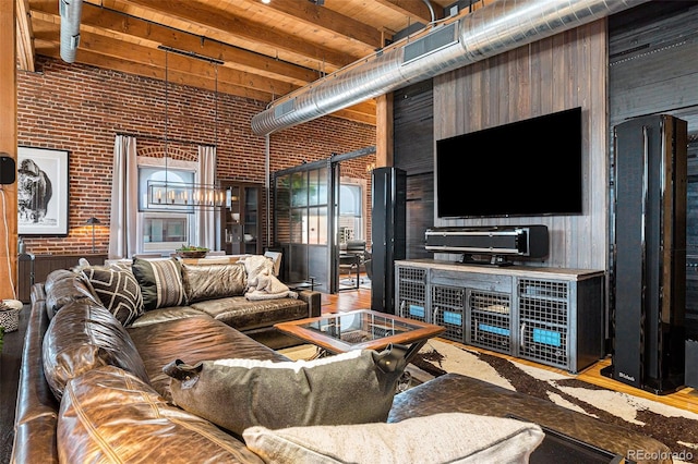 living room with a high ceiling and brick wall