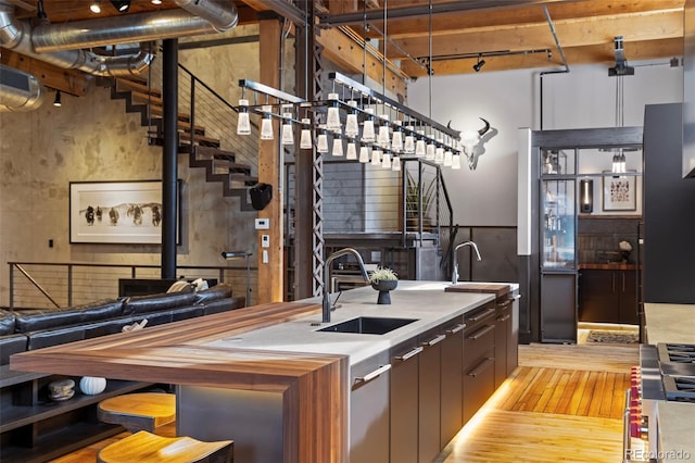 kitchen with gas stovetop, sink, track lighting, and light hardwood / wood-style floors