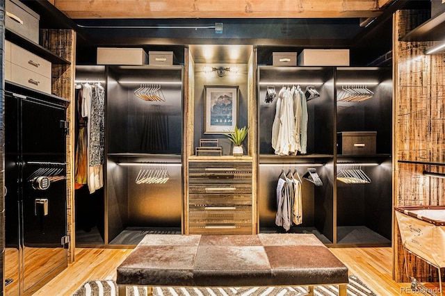 walk in closet with light hardwood / wood-style floors