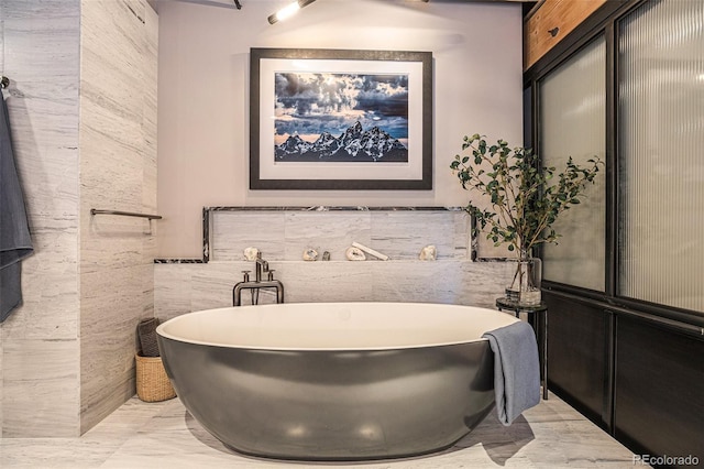 bathroom with tile walls, sink, and a bathtub