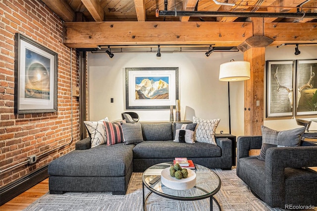 living room with beamed ceiling, brick wall, and hardwood / wood-style floors